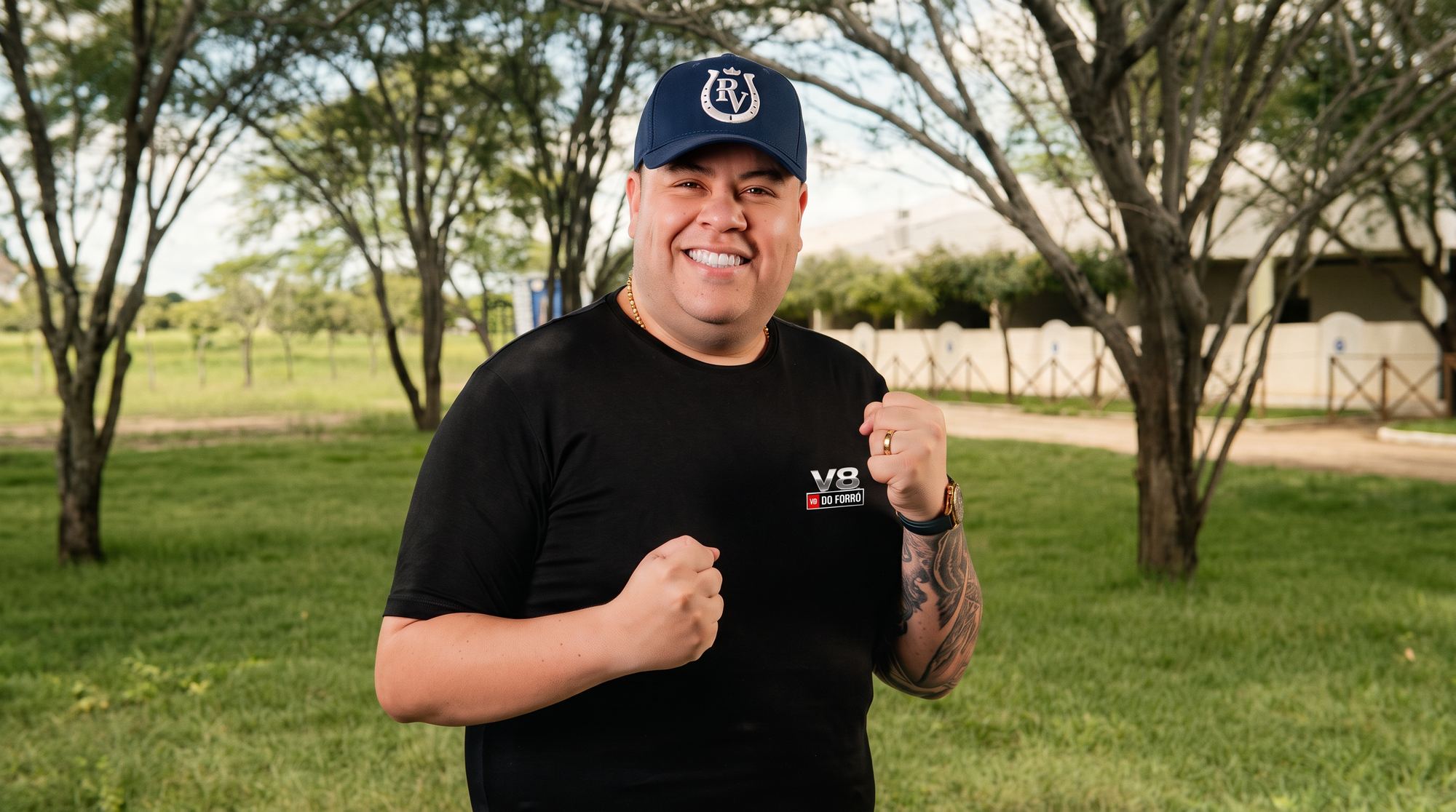 Rey Vaqueiro sorrindo, de boné e camiseta preta